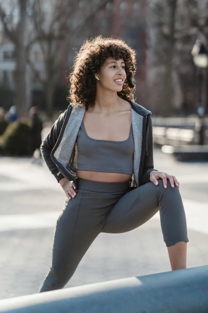 Sportswoman hip stretching out on street